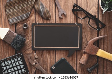 Labor Day and father's day background concept. Flat lay of construction blue collar handy tools and white collar's accessories over wooden background with black chalkboard.  - Powered by Shutterstock