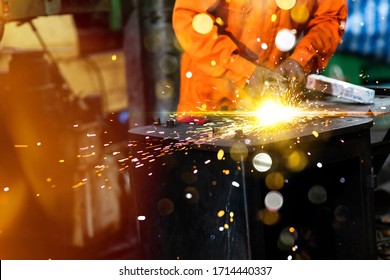 Labor man use Electric wheel grinding on steel structure in factory. Man Worker at industrial factory wearing uniform and hard hats. Engineering and architecture concept