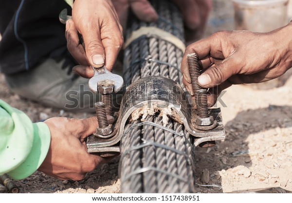 Labor\
man working with bridge sling tendon bolt tightening construction\
job - people at site construction working\
concept