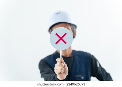 A labor showing a cross sign. - Shutterstock ID 2249626091