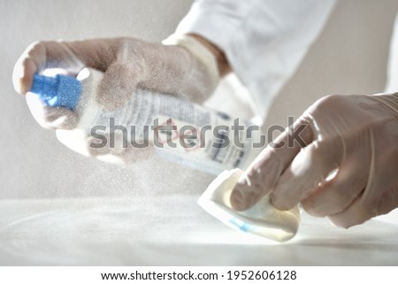 Laboratory agent nurse doctor cleaning desinfecting surface with desinfection reagent spray