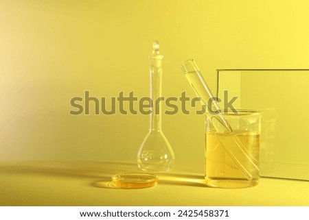 Laboratory analysis. Different glassware on table against yellow background, space for text