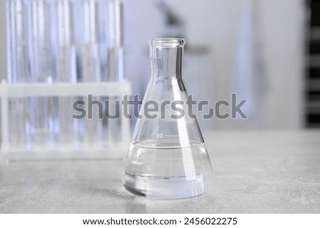 Laboratory analysis. Flask and test tubes on light grey table indoors