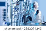 Laboratory assistant with microscope bio tech. Biologist at work. Scientist near bioreactor. Biologist in protective suit. Laboratory assistant makes scientific experiment. Biologist with flask