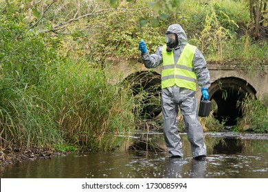 laboratory assistant in a special protective suit in the open air measures the level of environmental pollution with the device