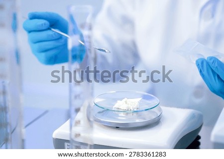 Laboratory assistant using spatula for measuring chemical substance on precision balance pharmacy research. Close up hand of chemist weighing pharmaceutical ingredient on digital scale in laboratory.