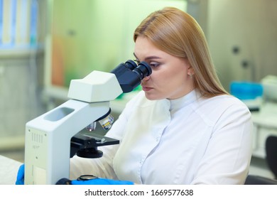 Laboratory assistant working with a microscope in a scientific laboratory. COVID-19. COVID Coronavirus - Shutterstock ID 1669577638