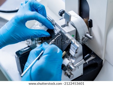Laboratory assistant works on a rotary microtome section and making microscope slides