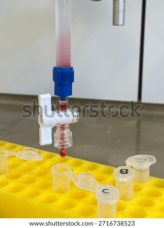 Laboratory burette with red solution drop, close up Science experiment setup in chemistry lab with stopcock and pipette tip; closeup view of liquid titration, measurement and research equipment in lab. 