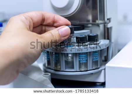 Laboratory concept; close up picture of the scientist put the vial of GC sample on autosampler plate Stock photo © 