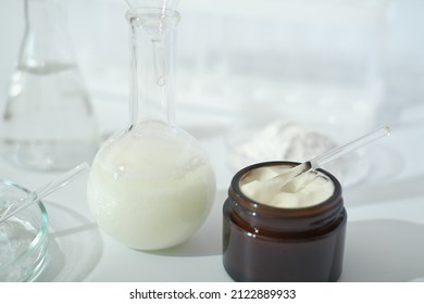 Laboratory Dishes And Glassware On A Lab Table. Fermentation, Fermented Beauty Skin Care. Container With Cream Or Solution Or Serum For Anti Age Treatment