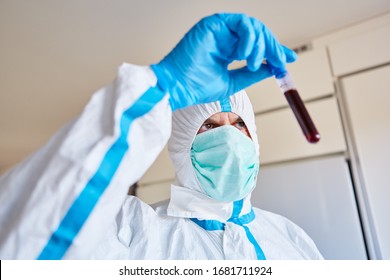 Laboratory employee in protective clothing with Covid-19 blood sample for test in the laboratory