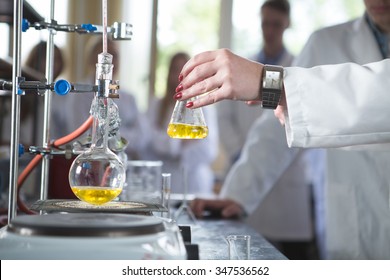 Laboratory equipment for distillation.Separating the component substances from liquid mixture.Pharmaceutical researcher holding Erlenmeyer flask demonstrating process in apparatus