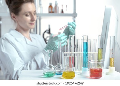laboratory equipment, supplies, jars, bottles, cylinders, beakers, graduate, test-mixer, medicine-glass. The laboratory assistant makes bacteriological inoculation in a petri dish with a glass 
