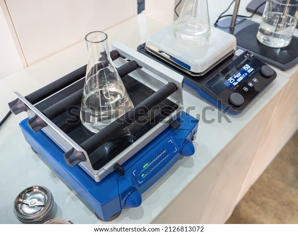 Laboratory\
equipment. Variants of laboratory shakers. Blue orbital lab shaker\
with flask filled with liquid. Equipment for laboratory research.\
Devices for studying composition of\
substances