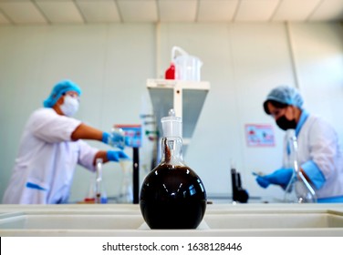 Laboratory Flask With Crude Oil. Lab Test  Petroleum In The Background.