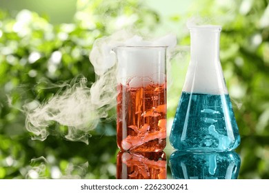 Laboratory glassware with colorful liquids on glass table outdoors. Chemical reaction