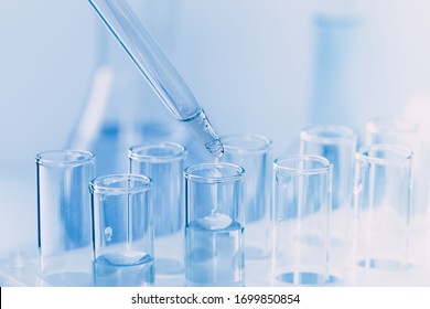 Laboratory glassware with a dropper dripping liquid into a test tube. scientific laboratory test tubes, laboratory equipment