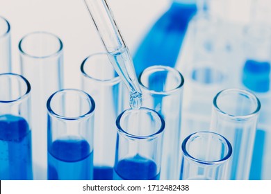 Laboratory glassware with a dropper dripping liquid into a test tube. scientific laboratory test tubes, laboratory equipment