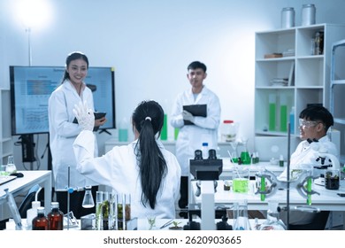 In the laboratory, a group of researchers meets to report their findings, discussing their work and preparing for future experiments, all focused on advancing science and health care.