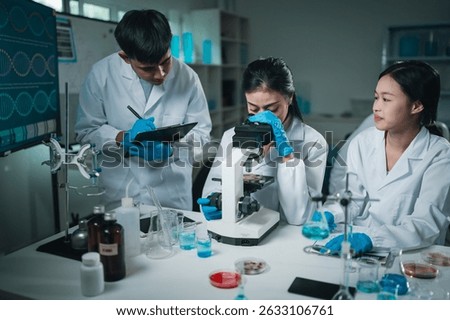 Laboratory microscope research scientists working in white lab coats conducting scientific analysis and testing biological samples for innovation in medical diagnostics and breakthroughs