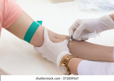 Laboratory with nurse taking blood sample from patient