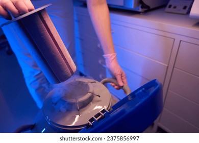 Laboratory researcher using cryogenic dewar for storage of biological specimens - Powered by Shutterstock