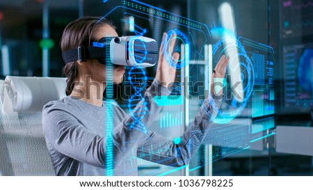 In Laboratory Scientist Wearing Virtual Reality Headset Sitting in a Chair Interacts with Futuristic Holografic Interface, Showing Neurological Data. Modern Brain Study/ Neurological Research Center.