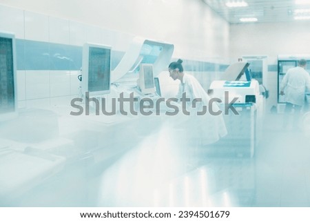 laboratory technician in lab coat performs series of tests on chemical analyzer in  bio laboratory. impersonal unrecognizable laboratory
blurred fuzzy background shot through glass with space toned 