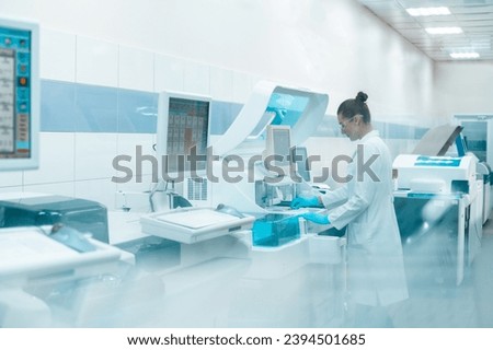 laboratory technician in lab coat performs series of tests on chemical analyzer in  bio laboratory. impersonal unrecognizable laboratory
blurred fuzzy background shot through glass with space toned 