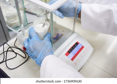 Laboratory Technician Weighs White Powder In Biochemical Laboratory, Closeup Of Weight And Technician Hands In Lab