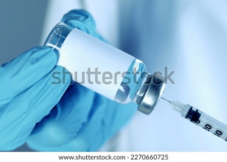 Laboratory worker filling syringe with medication from glass vial, closeup