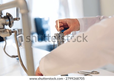 Laboratory Worker Heating Material Over Gas Bunsen Burner Flame in Chemistry Lab