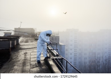 Laboratory worker on the roof conducting tests on subject of air pollution, sun is rising up and light is flooding the territory, copy space