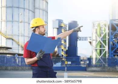 Laborer Outside A Factory Working Dressed With Safety Overalls Equipment