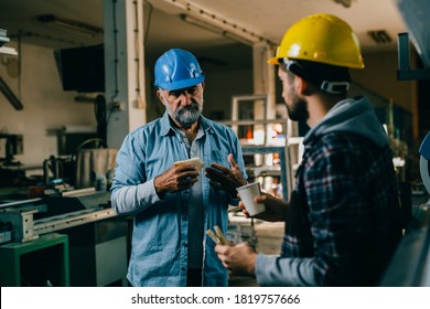 laborers talking while having lunch break in the factory - Shutterstock ID 1819757666