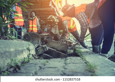 labors are constructing pedestrian walkways; workers building and installing stone tiles to build footpath