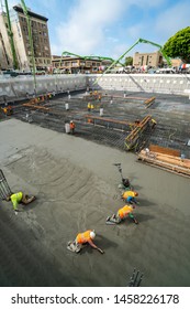 Labors Finishing The Garage Basement Floor After Foundation Concrete Mat Pour. 