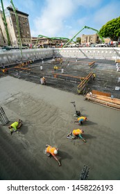 Labors Finishing The Garage Basement Floor After Foundation Concrete Mat Pour. 