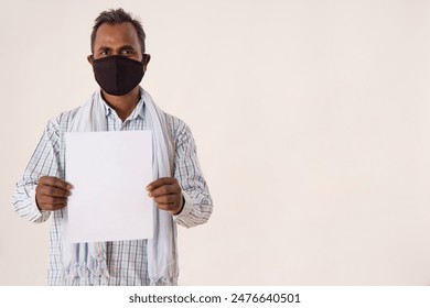 A LABOURER WEARING FACE MASK HOLDING A SHEET OF PAPER - Powered by Shutterstock