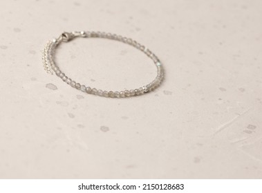 Labrador bracelet. Bracelet made of stones on hand from natural stone Labrador. Bracelet made of natural stones. Handmade jewelry. Handmade bracelets on light modern background. Thin bracelet.