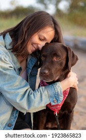 Labrador Retriever, Happy And Young Caucasian Millennial Woman In Denim Jacket Hugs Dog And Smiles, Dog And Human Friendship, Pet, Pit Bull, Dog Lover, Walking. Soft Selective Focus