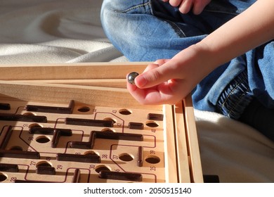 Labyrinth Maze Game. Wooden Toy, Old Style With A Metal Ball. Kids Hand Holding The Shinning Marble. Stockholm, Sweden.