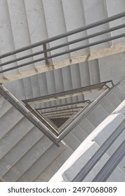 A labyrinth of stairs creates a visually intriguing and complex pattern. The stairs twist and turn, ascending and descending in multiple directions, forming a maze-like structure. 