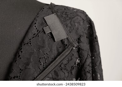 Lace black dress with a label for the brand name on the reverse side. Clothes on a tailor's mannequin - Powered by Shutterstock