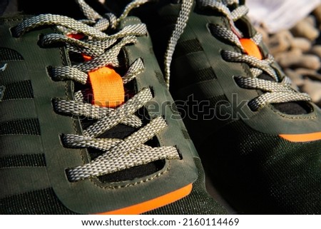 lacing green sneakers with orange inserts