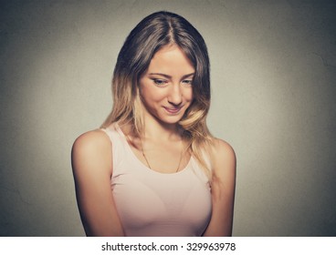 Lack Of Confidence. Shy Young Woman Feels Awkward Isolated On Grey Wall Background. Human Emotion Body Language Life Perception