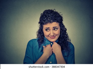 Lack Of Confidence. Shy Young Woman Feels Awkward Isolated On Gray Wall Background. Human Emotion Body Language Life Perception