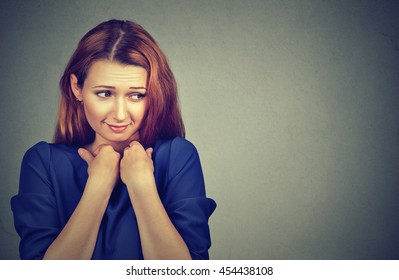 Lack Of Confidence. Shy Young Woman Feels Awkward Isolated On Grey Wall Background. Human Emotion Body Language Life Perception