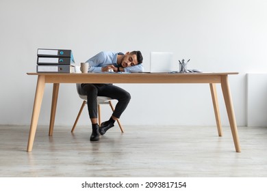 Lack of Energy Concept. Portriat Of Tired Young Middle Eastern Man Sleeping At Work, Exhausted Guy Sitting At Table With Pc Napping In The End Of Hard Working Day, Fatigued Male Worker Resting